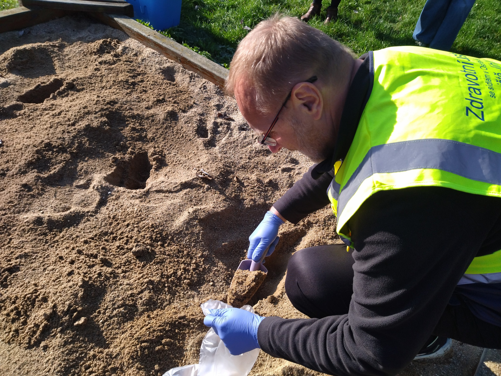 snímek - odběr vzorku písku pracovníkem Zdravotního ústavu