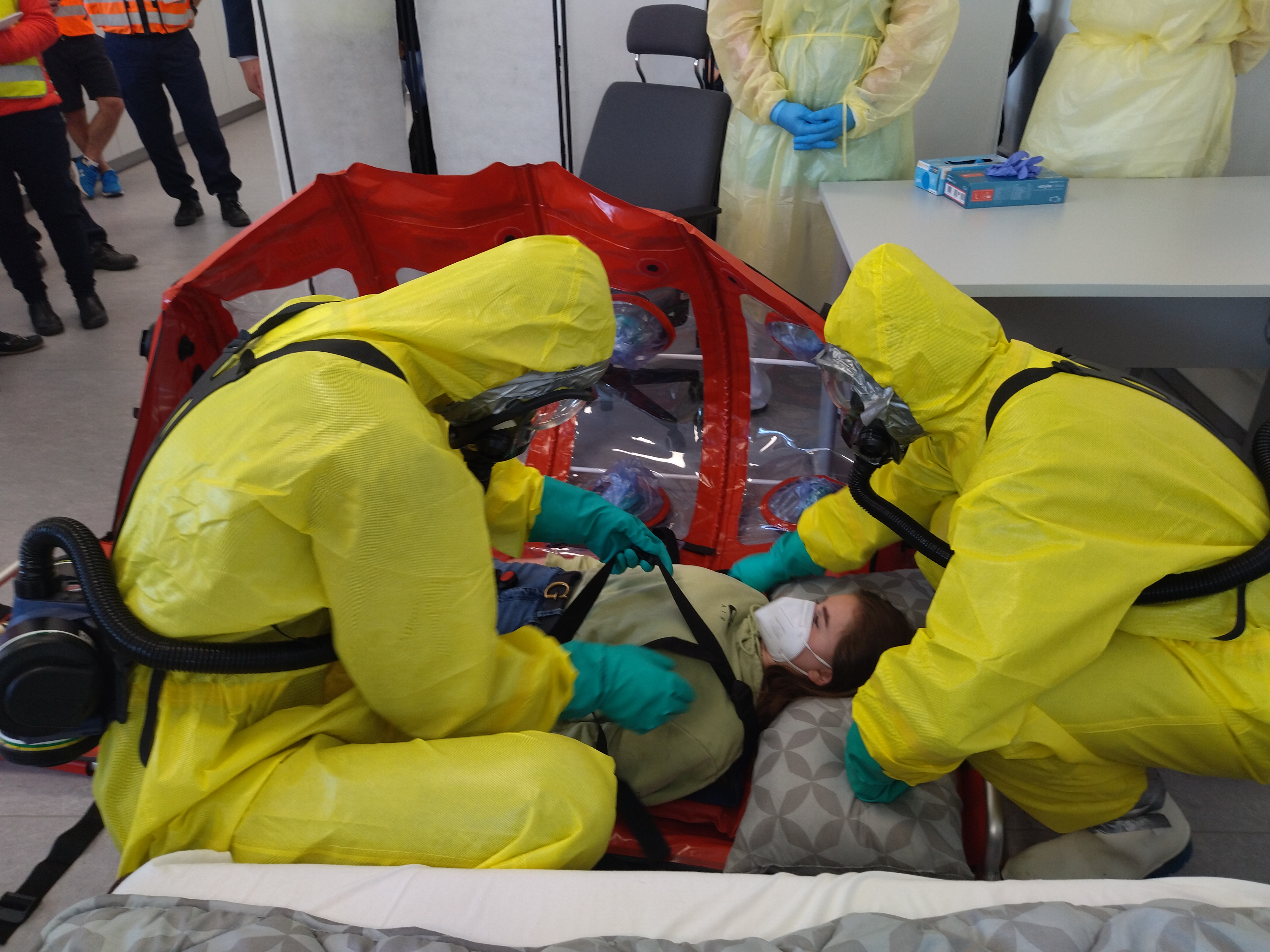 Fotka - Záchranný tým ukládá pacienta do ochranného vaku
